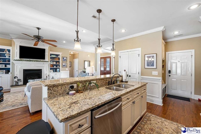 kitchen with stainless steel dishwasher, a kitchen island with sink, sink, and light stone countertops