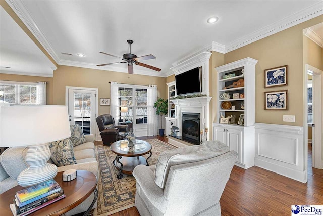 living room featuring dark hardwood / wood-style flooring, ornamental molding, and ceiling fan