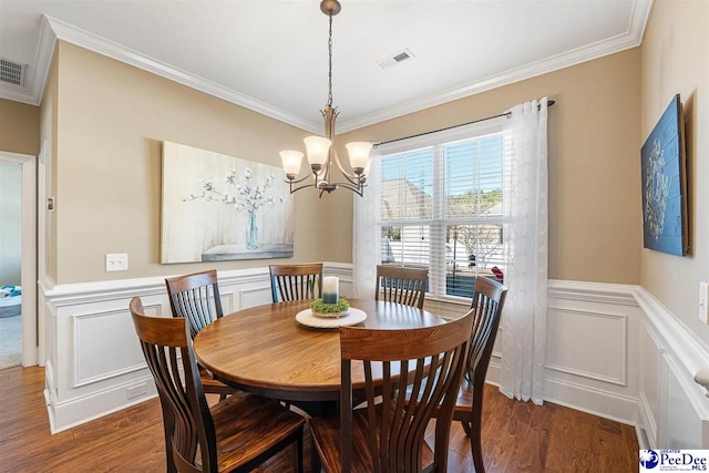 dining area featuring an inviting chandelier, ornamental molding, and dark hardwood / wood-style flooring