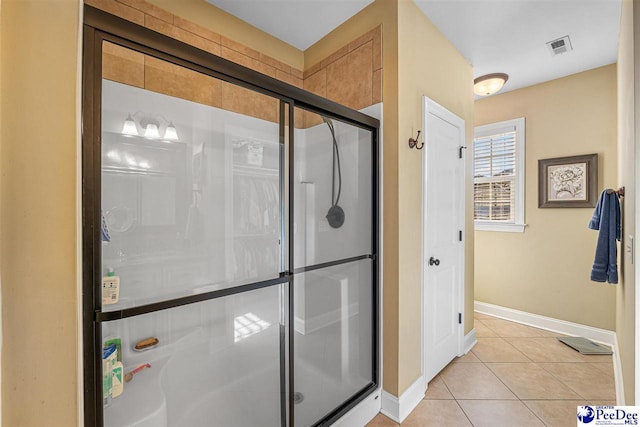 bathroom with tile patterned flooring and a shower with door