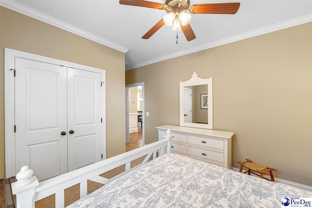 bedroom with crown molding, ceiling fan, and a closet