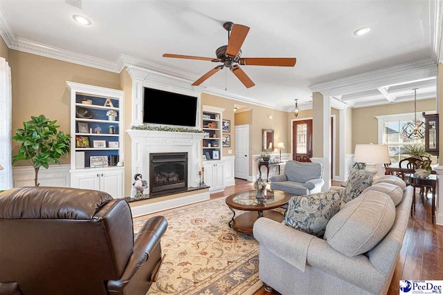 living room with crown molding, hardwood / wood-style flooring, and ceiling fan with notable chandelier