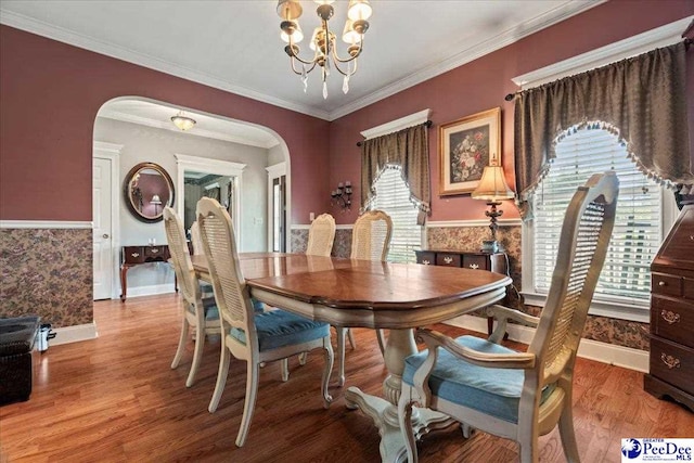 526 Shannon Rd, Marion, SC 29571 - dining area featuring an inviting chandelier, arched walkways, ornamental molding, wood finished floors, and baseboards