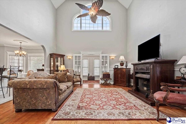 526 Shannon Rd, Marion, SC 29571 - living area with arched walkways, wood finished floors, high vaulted ceiling, and a fireplace with raised hearth