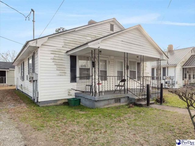 bungalow-style house with covered porch and a front yard