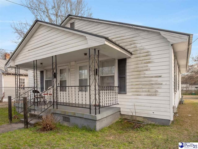 bungalow featuring a front yard and covered porch