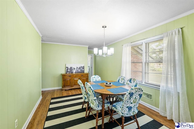 2105 W Downing St, Florence, SC 29501 - dining space with wood finished floors, a chandelier, ornamental molding, and baseboards