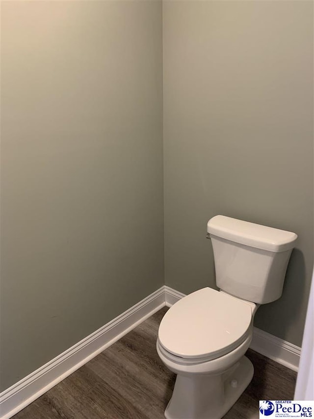 bathroom with wood finished floors, toilet, and baseboards