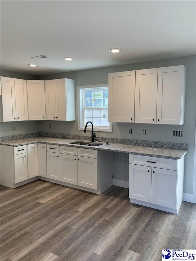 kitchen with dark wood finished floors, white cabinetry, and a sink