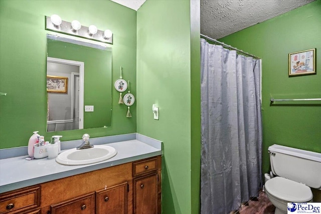 bathroom with vanity, walk in shower, a textured ceiling, and toilet