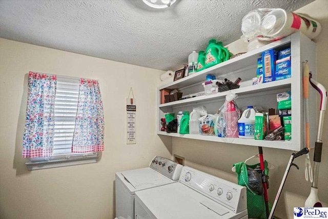 laundry room with washing machine and clothes dryer and a textured ceiling