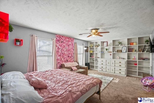 bedroom with multiple windows, ceiling fan, carpet, and a textured ceiling