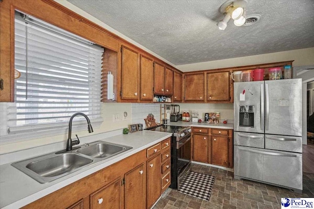 kitchen with stainless steel appliances, sink, and a textured ceiling