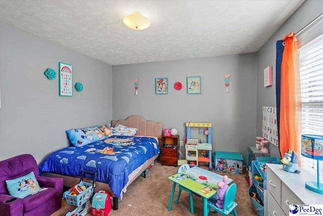 bedroom featuring a textured ceiling and carpet flooring