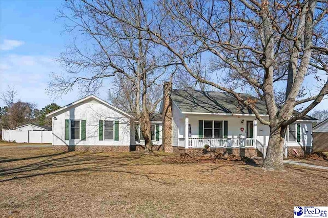 ranch-style house with a porch and a front lawn