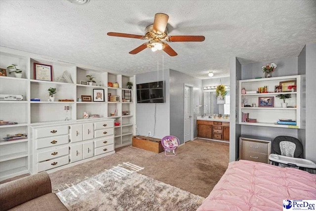 carpeted bedroom featuring ceiling fan, connected bathroom, and a textured ceiling