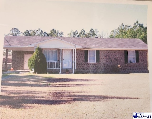 ranch-style home featuring brick siding and covered porch