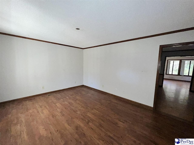 spare room with crown molding and dark hardwood / wood-style floors