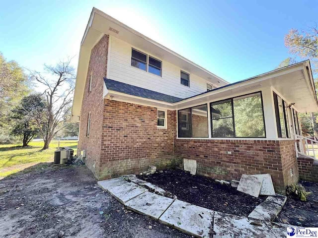 rear view of house featuring central AC