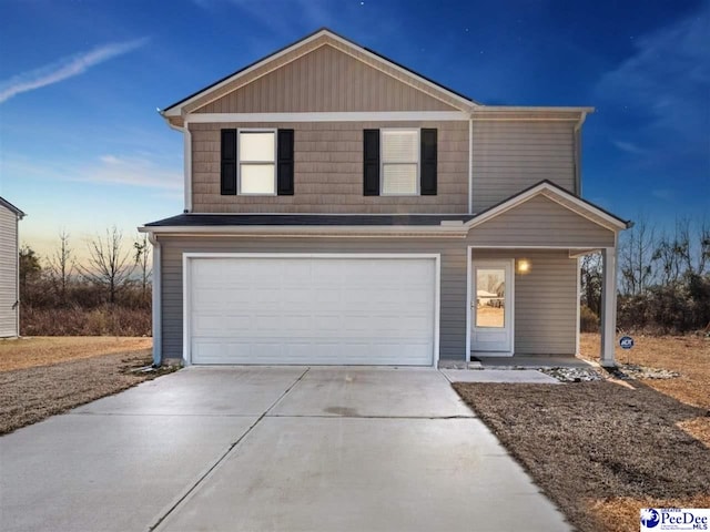 traditional home featuring concrete driveway and an attached garage