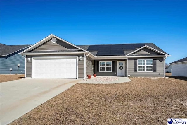 ranch-style house with a garage, solar panels, and concrete driveway