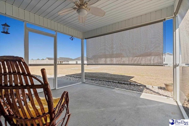 unfurnished sunroom with a ceiling fan