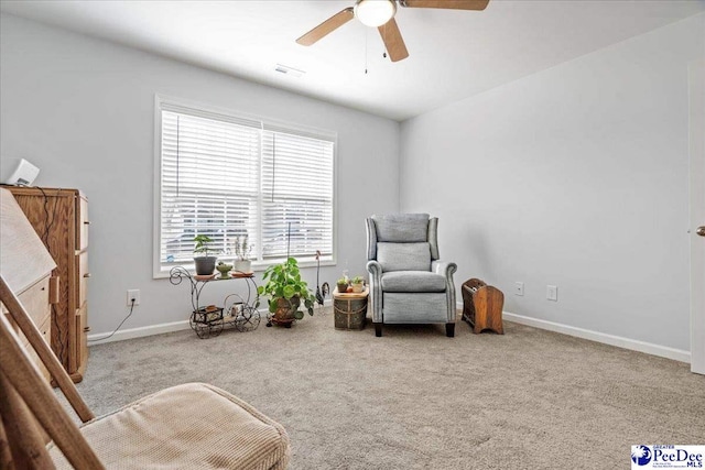 living area featuring light carpet, ceiling fan, visible vents, and baseboards