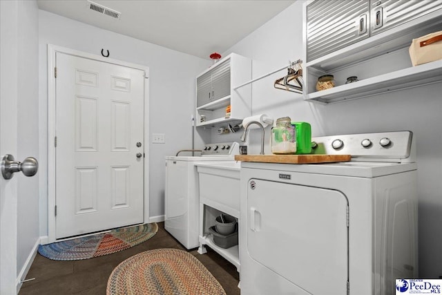 clothes washing area with laundry area, separate washer and dryer, visible vents, and baseboards