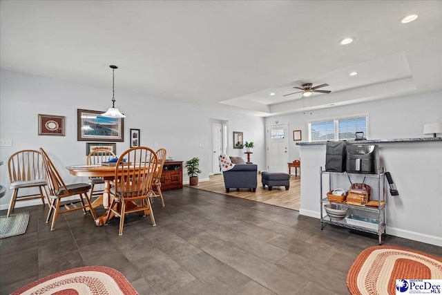 dining space featuring baseboards, a tray ceiling, a ceiling fan, and recessed lighting