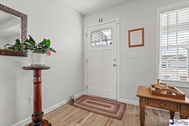 entryway with light wood-style floors, a wealth of natural light, and baseboards