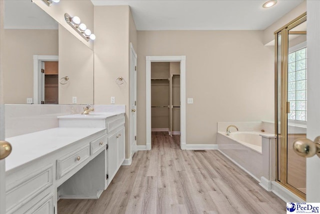 3401 Sussex Ct, Florence, SC 29501 - bathroom with vanity, wood finished floors, a walk in closet, and a bath