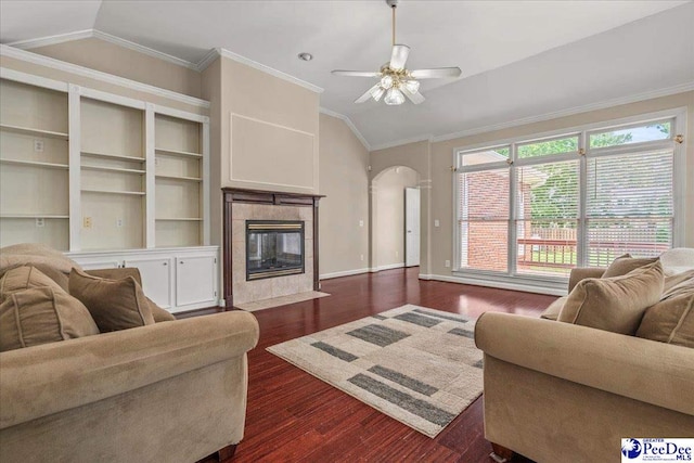 3401 Sussex Ct, Florence, SC 29501 - living area with vaulted ceiling, a tile fireplace, ceiling fan, dark wood-style flooring, and arched walkways