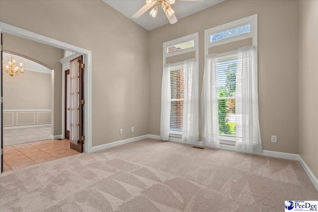 3401 Sussex Ct, Florence, SC 29501 - carpeted spare room with a ceiling fan, a chandelier, tile patterned flooring, and arched walkways