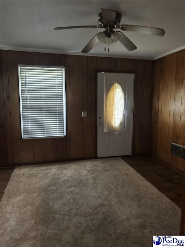 2122 Williams Gibbons Rd, Turbeville, SC 29162 - carpeted entrance foyer featuring ornamental molding, a ceiling fan, and wooden walls