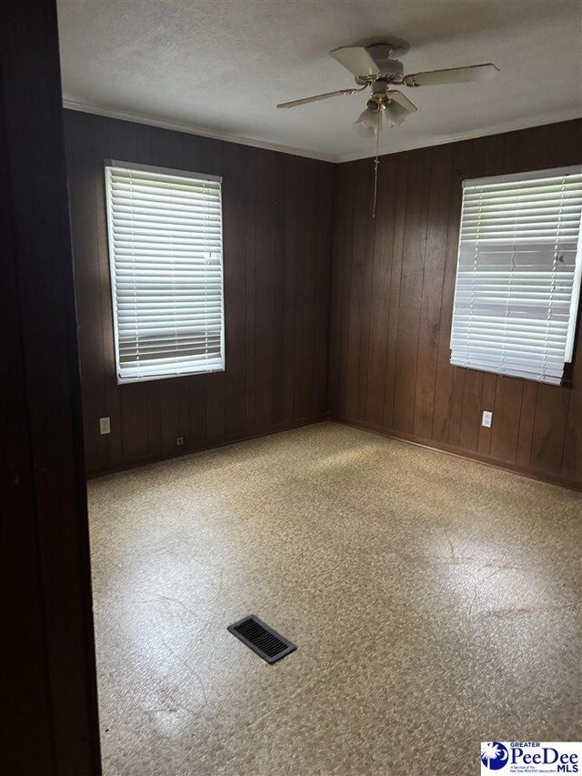 2122 Williams Gibbons Rd, Turbeville, SC 29162 - carpeted empty room with a ceiling fan, ornamental molding, and wooden walls