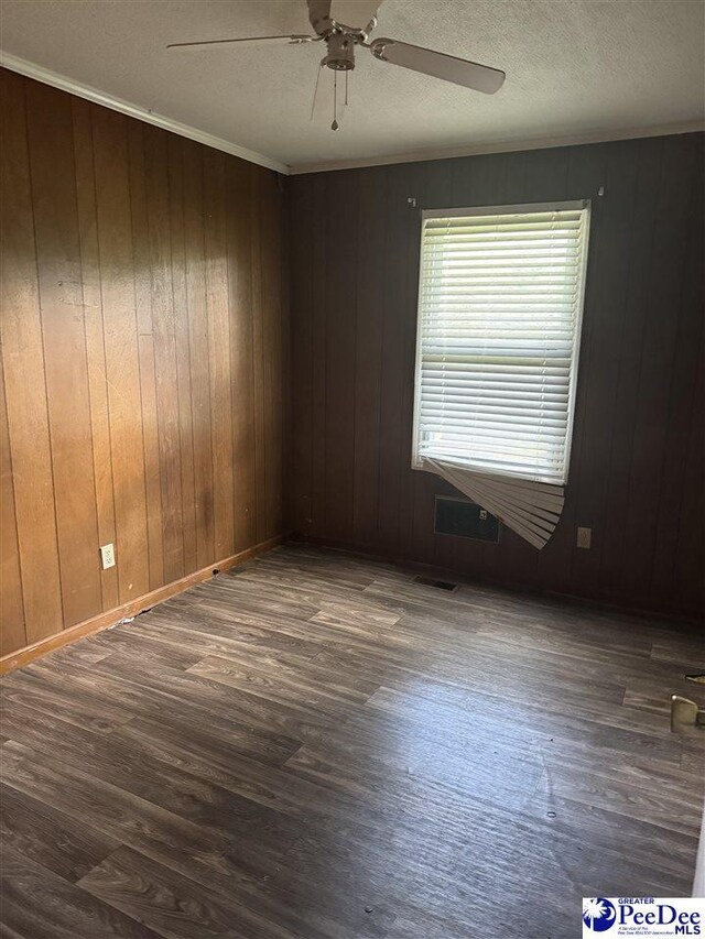 2122 Williams Gibbons Rd, Turbeville, SC 29162 - spare room with wood finished floors, a ceiling fan, wood walls, and a textured ceiling