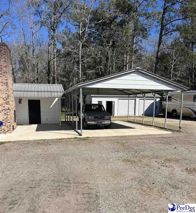 view of parking with a storage unit and a detached carport