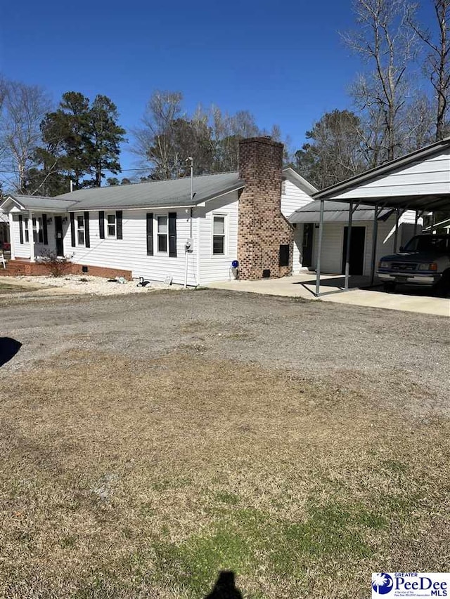 view of front facade featuring a carport and a chimney