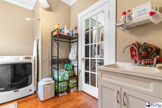 laundry room featuring washer / dryer, sink, and light wood-type flooring