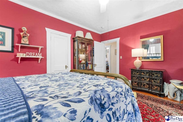 bedroom with hardwood / wood-style flooring, ceiling fan, and ornamental molding