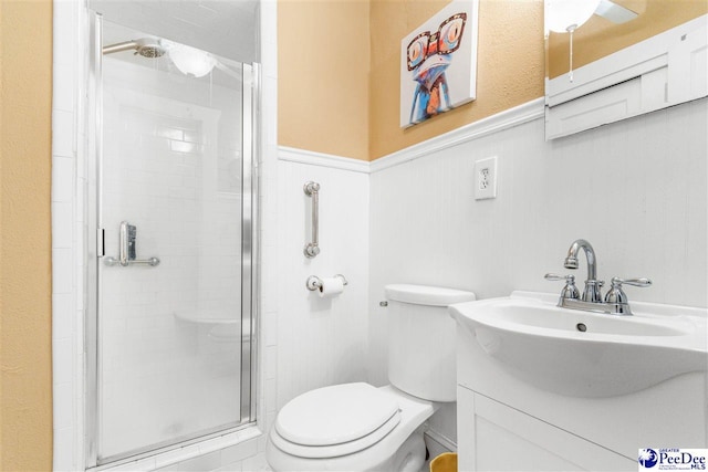 bathroom with vanity, toilet, and a shower with shower door