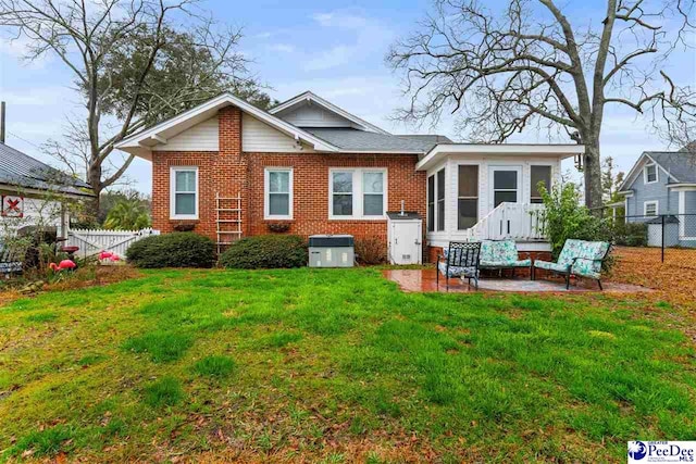 view of front of home with central AC, a front yard, and a patio area