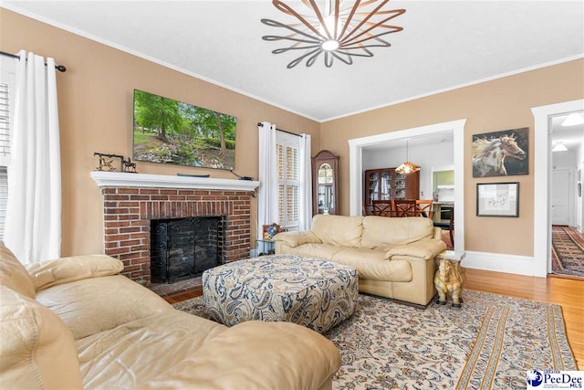 living room with crown molding, wood-type flooring, and a fireplace