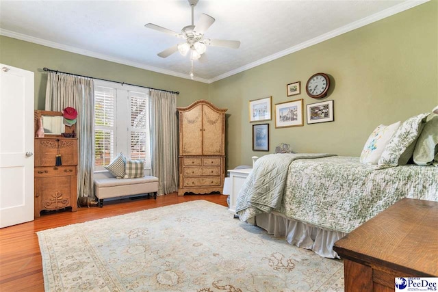 bedroom featuring crown molding, light hardwood / wood-style flooring, and ceiling fan