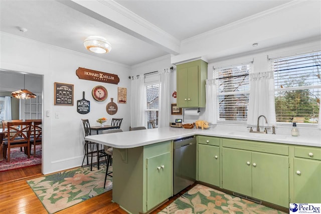 kitchen featuring sink, stainless steel dishwasher, green cabinets, kitchen peninsula, and crown molding