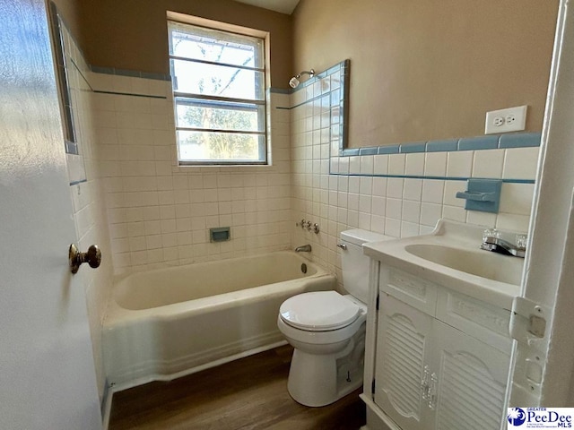 full bathroom with toilet, wood finished floors, vanity, tile walls, and shower / washtub combination