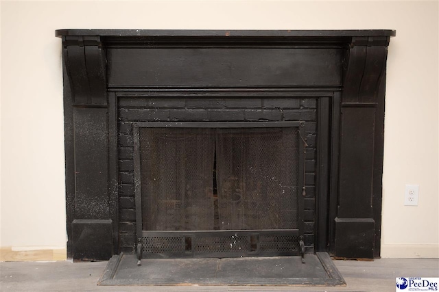 room details featuring a fireplace, baseboards, and wood finished floors