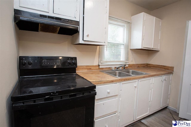 kitchen featuring electric range, light countertops, under cabinet range hood, white cabinetry, and a sink