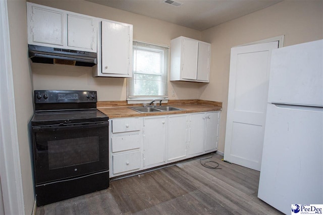 kitchen featuring under cabinet range hood, a sink, white cabinets, freestanding refrigerator, and black electric range oven