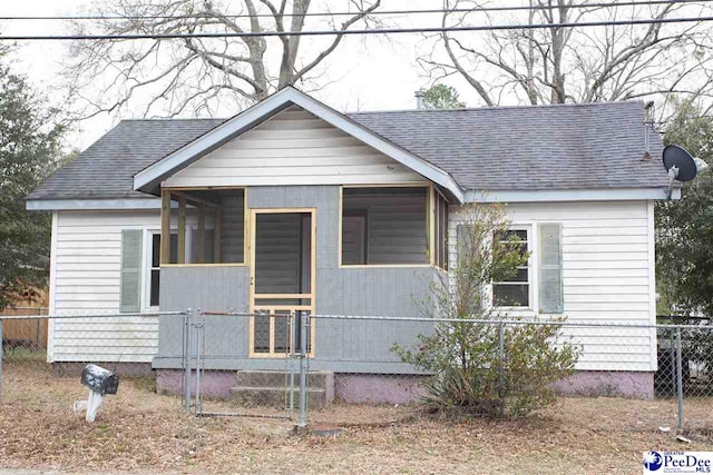 bungalow-style home featuring a shingled roof and a fenced front yard